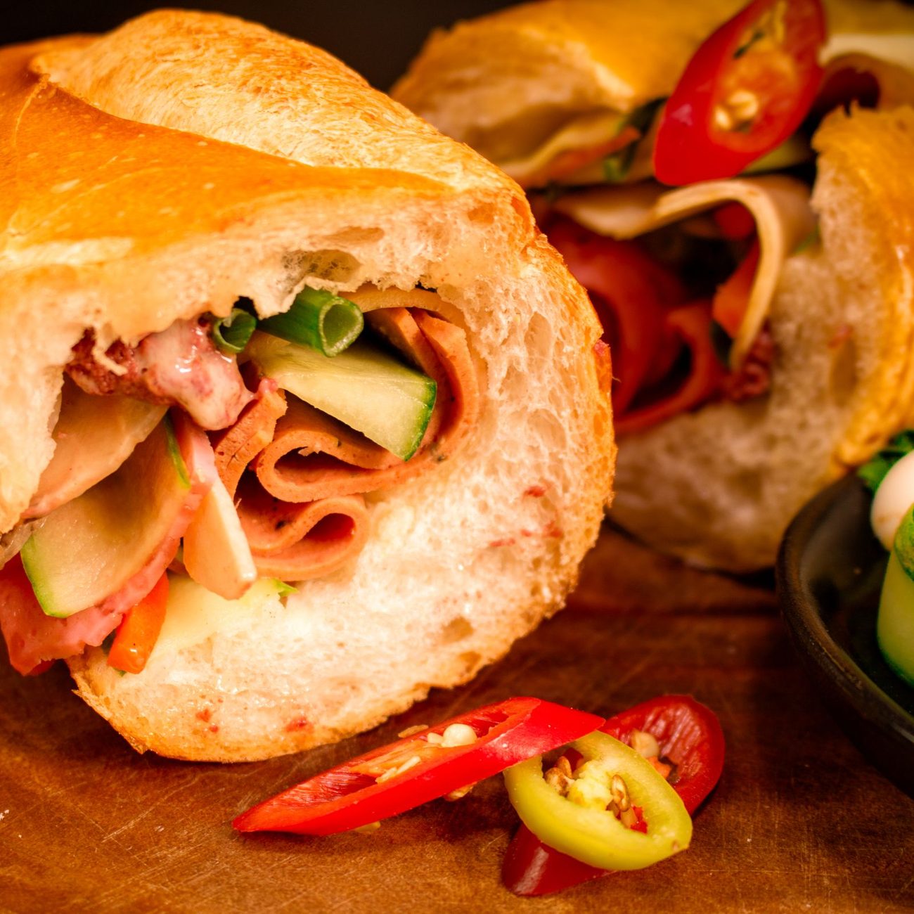 Vietnamese banh mi sandwich cut in half, showing fresh vegetables and filling